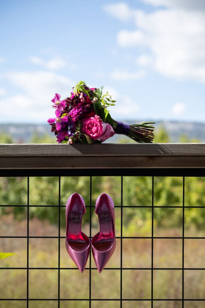 wedding bouquet and pink shoes hang on a railing at Wild Flower Farms in Gardiner NY