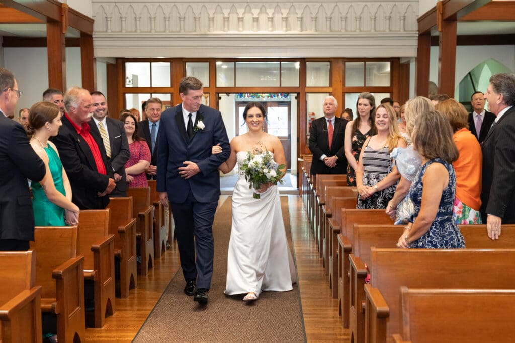 bride walks down aisle at St John Darien